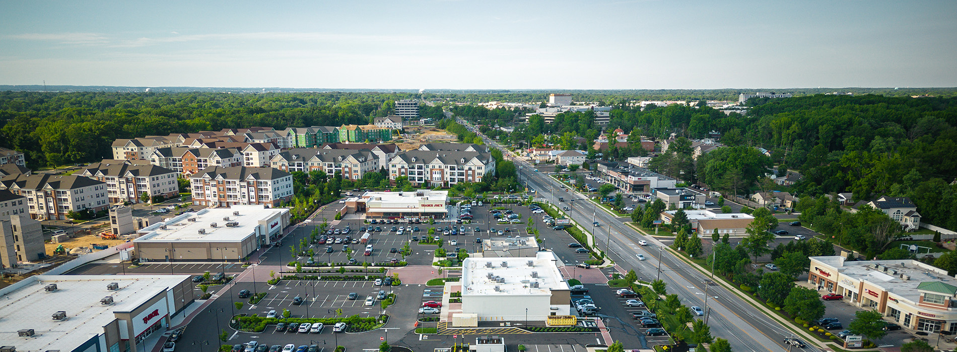 The image displays an aerial view of a suburban neighborhood with houses, roads, and parking lots.