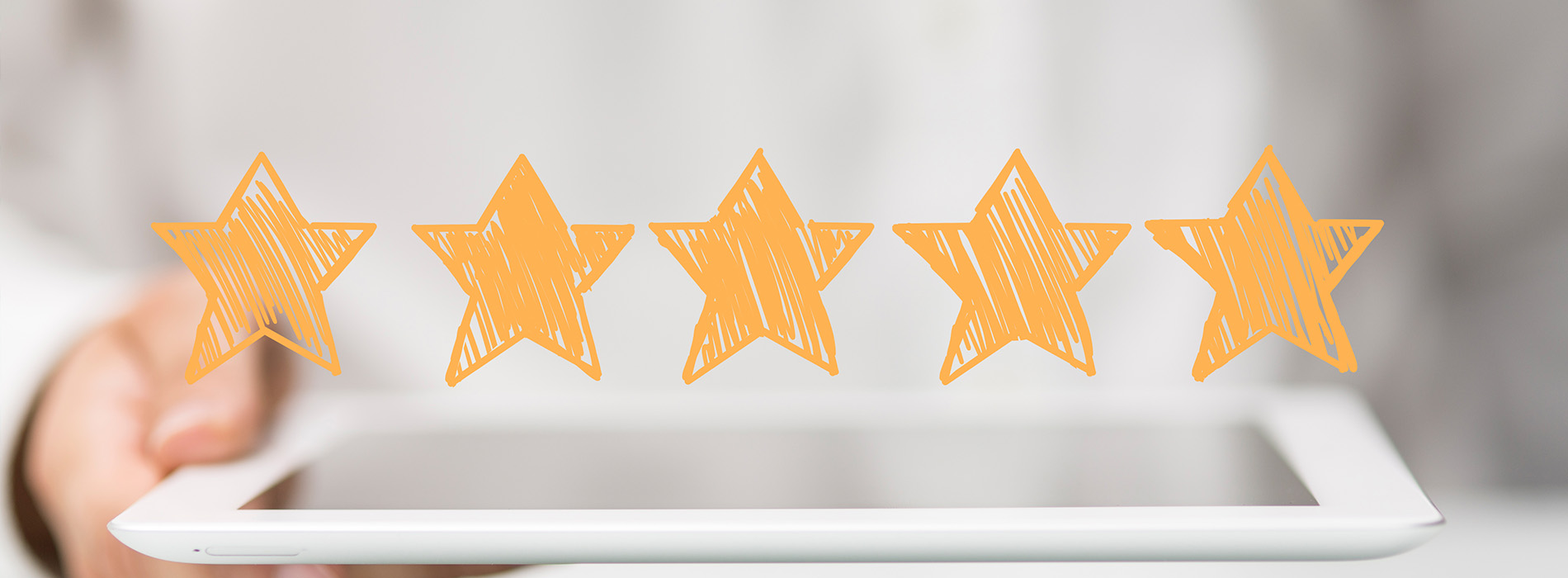 The image shows a hand holding a tablet with five orange star ratings on it, suggesting positive feedback or customer reviews for a product or service.