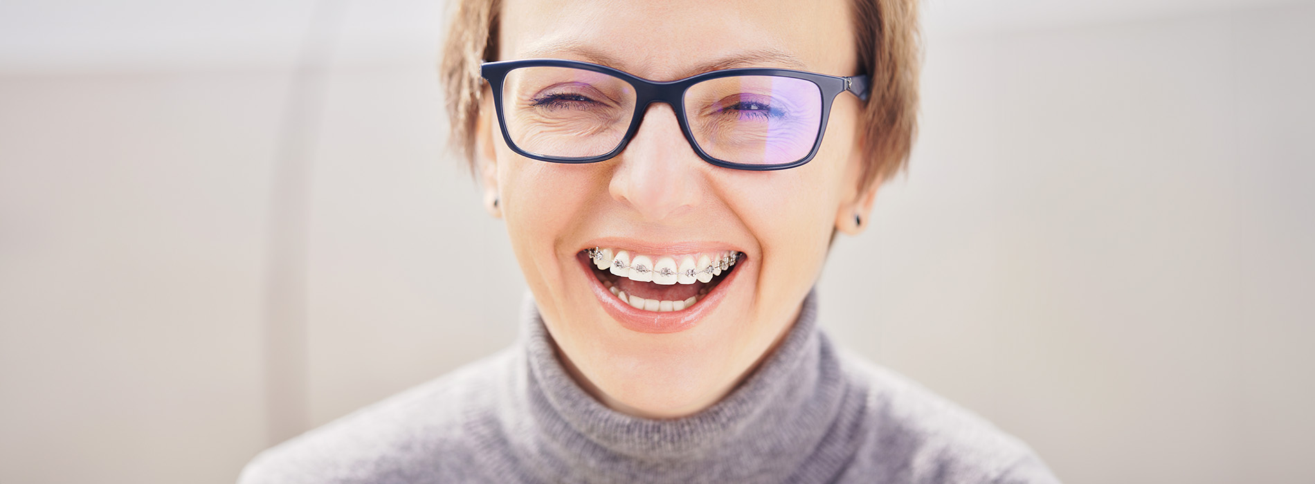 A woman with glasses smiling at the camera.