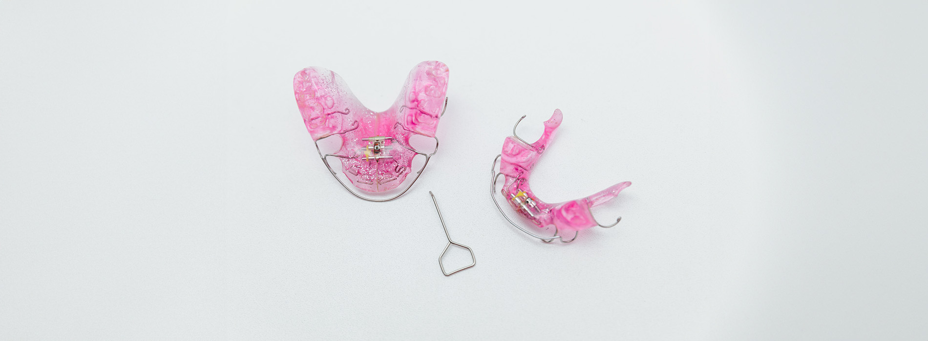 The image displays a pair of pink earrings with a clear background, likely placed on a white surface, showcasing their design and color.