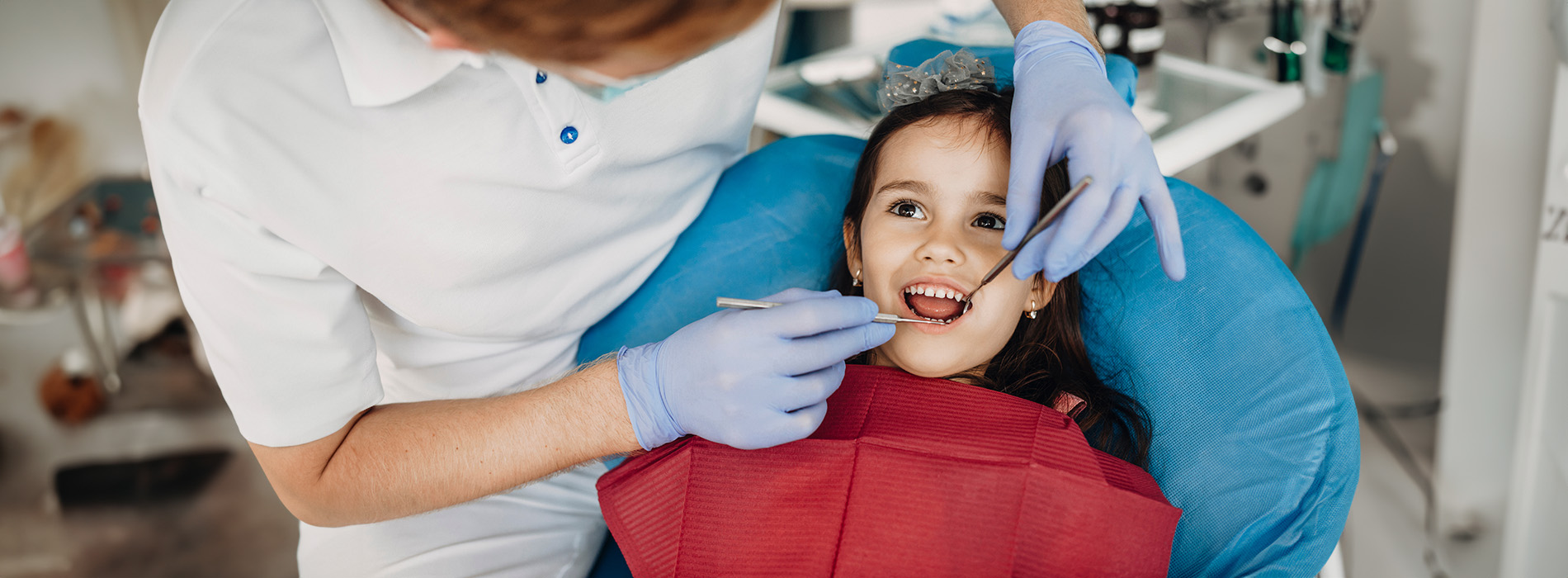A dental hygienist assisting a young child with a dental procedure.